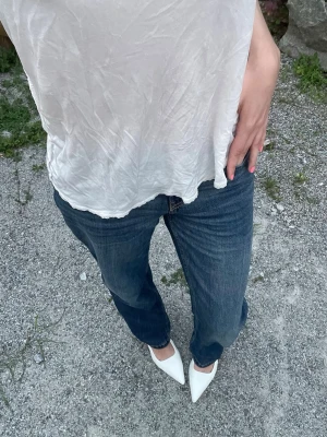 Low waist raka jeans - Låga raka mörkblå jeans från HM. Storlek young14+ 170, passar dock mig perfekt som brukar ha S i storlek och är 165cm lång (dock 172 med klackarna på bilden). Helt nya och oanvända då jag råkade köpa 2par istället för 1. 
