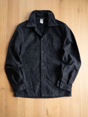 Vintage Le LABOUREUR Svart overshirt med stora fickor - Stilren svart overshirt i kraftigt bomullstyg med tre stora utanpåliggande fickor och klassisk krage. Knäppning framtill med fyra knappar och justerbara manschetter. Perfekt lager på lager-plagg för en avslappnad look.