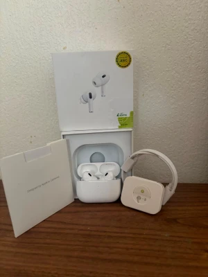 Apple AirPods Pro med laddningsetui - Säljer ett par vita Apple AirPods Pro med trådlöst laddningsetui. Hörlurarna har en stilren och kompakt design, levereras med originalförpackning och tillbehör. Perfekta för musik, samtal och träning tack vare brusreducering och smidig passform.