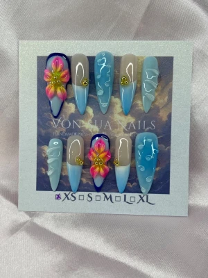 BlueOasis (XS);Medium Stiletto - Snygga handgjorda press-on naglar i en medium lång stilettoform med blå och nude bas, 3d swirl-detaljer och handgjorda 3D-blommor i rosa och gult. Några naglar har guldfärgade dekorationer för extra wow-effekt. Perfekt för dig som vill sticka ut med unika naglar.XS: 14 mm, 11 mm, 11,5 mm, 10 mm, 8 mm