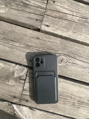 Svart mobilskal med kortfack - Snyggt svart mobilskal med inbyggt kortfack på baksidan. Skalet har en stilren design och är gjort i ett tåligt material som skyddar mobilen. Perfekt för dig som vill ha både skydd och plats för kort i ett och samma skal.