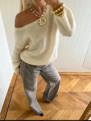 Off shoulder vit stickad tröja - Trendig off shoulder stickad tröja i mjuk, fluffig vit kvalitet.  Passar även M,L