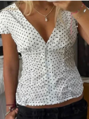 Prickig topp - Jättesöt prickig blus/topp. Köpt på Vinted och lappen är borta så vet tyvärr inte märke. För stor för mig så därför jag säljer den. Skulle säga den är XS/S. Första bild lånad på en likadan eller liknade!!