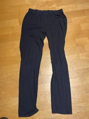 Svarta leggings med rak passform - Säljer ett par svarta leggings med rak passform och resår i midjan. De är enkla och stilrena, perfekta till många olika outfits. Materialet ser ut att vara mjukt och stretchigt för extra komfort.
