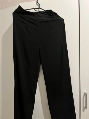 Svarta basic leggings - Säljer ett par svarta leggings med hög midja och stretchigt material. De har en enkel och clean design utan synliga detaljer eller fickor. Perfekta att matcha med oversized tröjor eller hoodies.