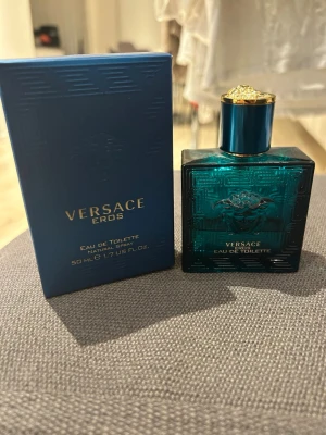 Versace Eros Eau de Toilette 50ml - Versace Eros Eau de Toilette i en snygg turkosblå glasflaska med guldiga detaljer och Medusa-huvud på framsidan. Flaskan rymmer 50 ml och kommer med originalkartong. En ikonisk doft med lyxig känsla och stilren design. Köpte den för ett tag sen men gillar inte längre men annars jättegod har ungefär 30-25 ml kvar av 50 ml.
