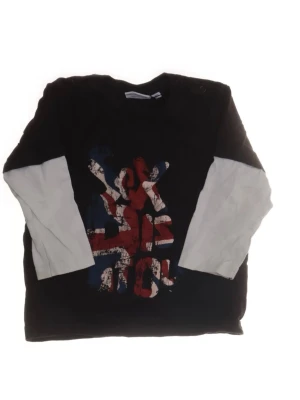 Svart långärmad t-shirt med tryck - Cool svart långärmad t-shirt med vita ärmar och ett stort tryck där det står ”Sex pistols” (bandet!) i rött, vitt och blått framtill. Perfekt för dig som gillar grunge eller streetwear och vill ha en matchande mode-bäbis! Skön passform för din lilla, passar till det mesta. Storlek 86 för småbarn. 