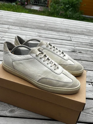Vita sneakers i läder från C.QP - Nypirs: ca 3500kr                           Storlek: 44.                                           Made in Portugal. Stilrena vita sneakers från C.QP i mjukt läder med detaljer i mocka. Klassisk låg modell med vita snören och diskret logga på plösen. Snygg minimalistisk design som passar till det mesta. Yttersula i gummi för bra grepp. Hör av er vid minsta fundering! Mvh Axel