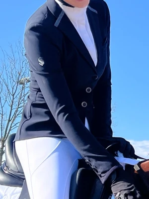 Marinblå ridkavaj med detaljer - Säljer min fina samshield kavaj då den inte kommer till använding längre. Super fin kvalitet och inga defekter! Kan skicka fler bilder vid önskemål 🥰 är en fransk 32 men passar mig som brukar ha storlek S/34 i vanliga fall! 