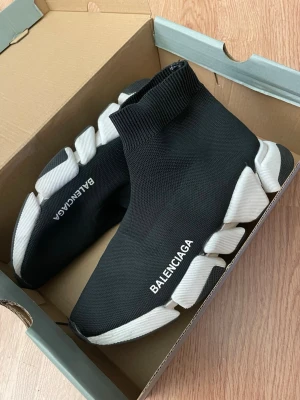  Speed Trainer svarta sneakers - Svarta  Speed Trainer sneakers med vit chunky sula och stickad strumpdesign. Skorna har logga på sidan och en elastisk ovandel i textil som sitter tight runt foten. Sulan är kraftig och har en futuristisk look.Jag har använt dom de är inte helt nya