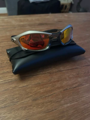 Oakley splice  - Coola oakley solglasögon med silvrigt båge och spegelglas i röd-orange ton. De har en sportig, futuristisk design och kommer med ett svart fodral. Perfekta för dig som vill sticka ut och ha en unik stil i solen. Skriv om frågor
