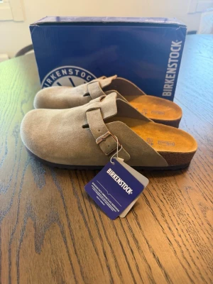 Birkenstock Boston - Säljer ett par helt nya Birkenstock Boston i den klassiska färgen Taupe (storlek 42). De levereras i originalkartong och är självklart noggrant kontrollerade innan de skickas. ☑️📦 Hör gärna av dig om du vill ha fler bilder eller har några frågor – jag svarar snabbt! 