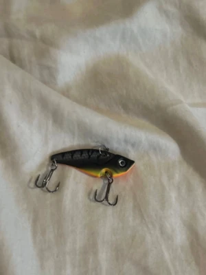 Fiskedrag i svart och orange - Säljer ett fiskedrag med svart ovansida, orange och gul undersida samt silverdetaljer. Draget har två trekrokar och ett realistiskt fisköga. Perfekt för fiskeentusiasten som vill ha något färgglatt i lådan.