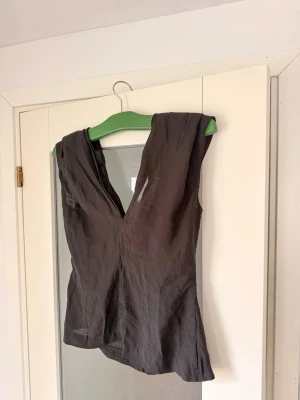 Svart topp från Wakakuu Icons  - Elegant svart topp från Wakakuu Icons med djup V-ringning både fram och bak. Stilren och feminin modell som passar lika bra till vardag som fest. 