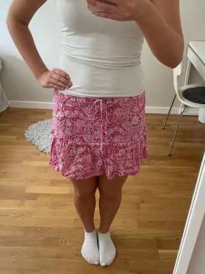 Rosa kjol med inbyggda shorts - Superfin rosa blommig kjol med inbyggda shorts från Zara i storlek M. Pris kan alltid diskuteras och skriv om du har några frågor!💗