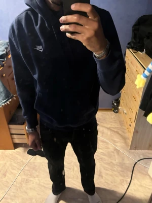 Mörkblå Nike hoodie med logga - Säljer en mörkblå hoodie från Nike med klassisk vit logga på bröstet. Hoodien har huva och lång ärm, samt en relaxed passform som är perfekt för chill dagar. Materialet känns mjukt och skönt, troligen bomull eller en bomullsblandning. ‼️‼️‼️ Oljie fläckar på tröjan för jag har jobbat med den, enkel lösning att fixa det‼️‼️‼️