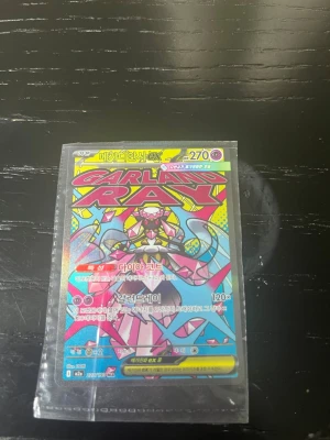 Pokémonkort Gardevoir EX - Unikt Pokémonkort med Gardevoir EX-motiv i färgstark design. Kortet har starka färger som rosa, blått och gult och ligger i ett plastfodral. Perfekt för samlare eller Pokémonfans som vill utöka sin samling.