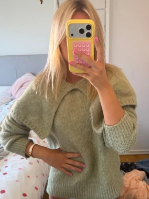 Grön stickad tröja med krage - Snygg ljusgrön stickad tröja med bred krage och långa ärmar. Tröjan har en avslappnad passform och är gjord i ett mjukt, fluffigt material som känns riktigt skönt mot huden. Perfekt för dig som gillar en trendig och cozy look.