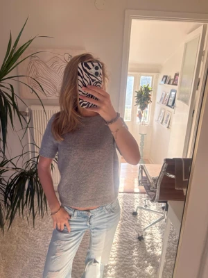 Ljusgrå stickad kortärmad topp - Superfin ljusgrå stickad topp med korta ärmar och rund hals. Mjuk och skön, perfekt till jeans eller kjol. Enkel och stilren design som passar till många olika looks. Storlek xs och är ifrån Zara!!🤍