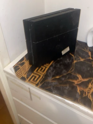 Svart PlayStation 4 konsol - Säljer en svart PlayStation 4 konsol från Sony. Konsolen har en stilren, rektangulär design med mattsvart finish och två USB-portar på framsidan. Perfekt för gaming och streaming. Köptes 2023 pris kan diskuteras