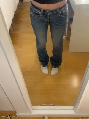 Blåa low waist Miss me jeans  - Säljer ett par blå bootcut jeans med låg midja och coola detaljer från Miss me då de är för stora för mig                                                                 Storlek W26, L32 däremot upplever jag att de är lite större i storleken