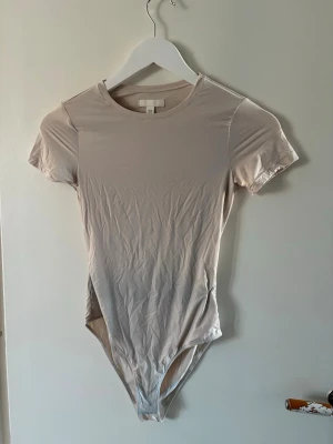 Body - T-shirt body från H&M, beige aktig, storlek xs, väldigt skönt matrial