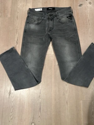 Grå tvättade jeans med raka ben - Snygga grå jeans med tvättad look och slitningar vid fickorna. Helt nya anbass. 