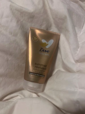 Dove Summer Revived brun utan sol - Dove Summer Revived gradual self-tan för ansikte och kropp. Ger en naturlig solkysst ton för medium till mörka hudtoner. Tuben är guldbronsfärgad med vitt lock och rymmer 75 ml. Perfekt för dig som vill ha glow året runt. Har använt 3 gånger.