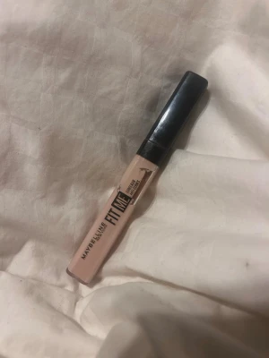 Maybelline Fit Me Concealer 08 - Maybelline Fit Me Concealer i nyansen 08. Kommer i en smidig tub med svart lock och applikator. Concealern har en ljus beige ton som passar för att täcka mörka ringar och ojämnheter. Perfekt för en naturlig look och enkel att använda i vardagen. Har använt den några gånger.