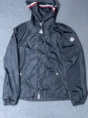 Moncler windbreaker svart  - Moncler Windbreaker med NFC Scan, Perfekt för hösten,Storlek M med tagg, nytt skick. Om ni har frågor är de bara att skriva. OBS! PRIS kan diskuteras