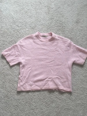 Ljusrosa stickad t-shirt från Gina Tricot  - Söt ljusrosa stickad t-shirt från Gina Tricot i mjukt material. Modellen har korta ärmar, ribbstickad halsringning och nederkant. Perfekt för en chill och trendig look. Storlek S. Ur deras premium kollektion. Skriv vid intresse💞💞priset går att diskutera 