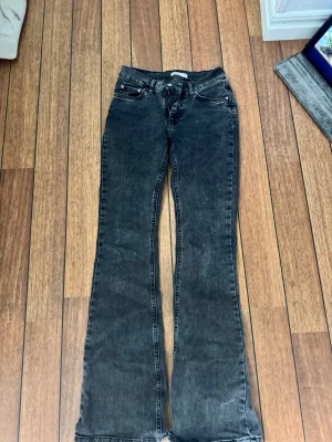 Svarta bootcut jeans - Säljer ett par svart/gråa bootcut jeans som är använda väldigt få gånger. Säljer dom då jag aldrig använder dom längre och för dom börjar bli försmå. 