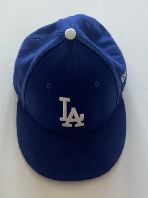 Blå LA keps i väldigt bra skick - Snygg blå keps med böjd skärm och broderad LA-logga i vitt framtill. Klassisk basebollmodell med små ventilationshål och MLB-logga baktill.