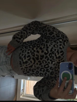 Grå leopardmönstrad stickad tröja Zara - Säljer en grå stickad tröja från Zara med leopardmönster i svart och beige. Tröjan har rund halsringning, långa ärmar och ribbade muddar. Perfekt för dig som gillar djurmönster och vill ha en trendig och mysig look. Pris kan absolut diskuteras!