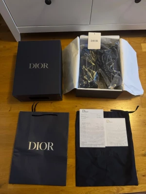 Svarta sneakers med vita detaljer - Säljer ett par svarta sneakers med vita kontrastsömmar och chunky sula. Skorna har en sportig siluett med mesh och läderdetaljer. Levereras med originalkartong, dustbag och påse. Storlek 43.