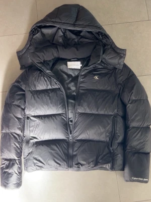 Calvin Klein jacka - Svart puffig jacka i strl M från Calvin klein.                                  Använt fåtal gångern men  är som helt ny