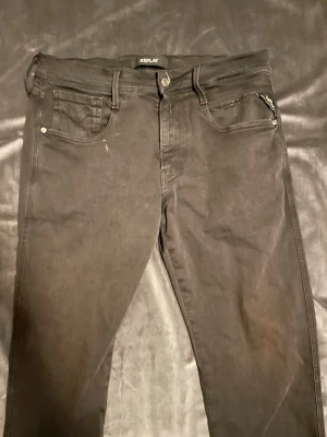 Replay jeans  - Säljer ett par svarta jeans från Replay med smal passform och klassisk femficksdesign. Jeansen har en snygg dragkedjedetalj på myntfickan och är tillverkade i stretchigt material för extra komfort. Perfekta för en trendig och avslappnad look.