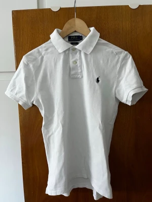 Ralph lauren Polo piké  - Vit Ralph Lauren Pike i storlek S slim fit vilket gör att den sitter bra runt armband på en. Inga skador på materialet och har bibehållit sin vita stilrena färg