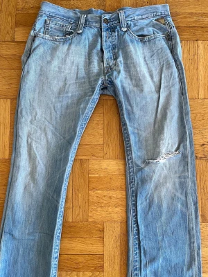 Ljusblå Replay Jens med unika slitningar. - Säljer ett par ljusblå jeans från Replay med riktigt feta slitningar.Jeansen har raka ben och detaljer i metall vid fickorna. Perfekta för dig som gillar en avslappnad och trendig stil. Storlek: W34-L34. Det är bara att höra av dig vid frågor.🙋‍♂️
