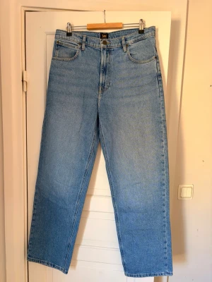 Ljusblå raka jeans från Lee - Säljer ett par klassiska ljusblå jeans från Lee med rak passform. Storlek - W32 L34 Jeansen har fem fickor, bälteshällor och Lee-lapp bak i midjan. Modellen är Asher