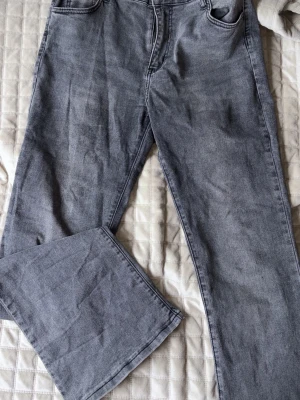 Grå bootcut jeans med hög midja - Säljer ett par grå jeans med bootcut passform och hög midja. Jeansen har klassiska fem fickor och är tillverkade i ett mjukt denimtyg. Perfekta för en avslappnad och trendig look. Från SHEIN 