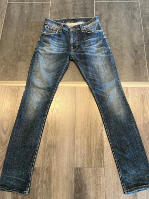 Nudie Jeans 31/34 - Snus Faded - Riktigt snygga Nudie Jeans i storlek 31/34. Jeansen har riktig sköna fades med tiden, inklusive en snygg snus fade på fickan som ger dem extra karaktär.  Perfekta om du gillar den slitna/vintage Nudie-looken. Bra skick och mycket liv kvar i dem.
