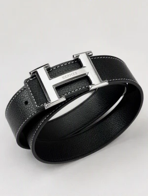 Svart H-bälte - Snyggt svart bälte med klassiskt stort H-spänne i silverfärgad metall. Skärpet har vit kontrastsöm längs kanterna och är gjort i exklusivt skinn. Perfekt accessoar för att lyfta din outfit.