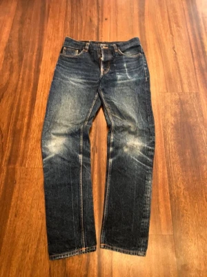 Nudie jeans  - Riktigt feta Nudie Jeans i modellen Steady Eddie II. Sitter ganska straight skulle jag säga, lite tapered. Snygg blå färg med snygga fades och slitningar och allt kommer bara bli snyggare med tiden. Storleken är W31 L34 men kolla måtten för mer exakt!  Kom med bud! Pris kan diskuteras  ✔️ Skickas inom max en dag😊  Tänk på att måtten kan variera med +-1cm då jag inte är en professionell mätare!  Mått: Ytterbenslängd: 107 cm Midja: 41,5 cm Benöppning: 17,5 cm  Vid fler frågor är det bara att höra a