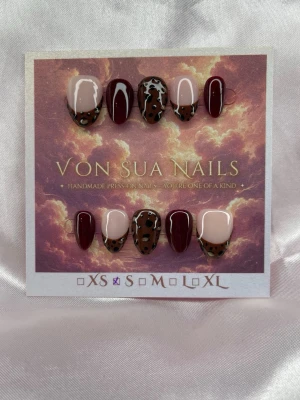 LadyLeo (S);ExtraShortAlmond  - Snygga unika handgjorda press-on naglar i storlek S: 15 mm, 11,5 mm, 12 mm, 11 mm, 9 mm . Mix av vinröda, nude bas och leopardmönstrade naglar med glansig finish och extra kort mandelform. Perfekt för dig som vill ha en unik och trendig look.S: 15 mm, 11,5 mm, 12 mm, 11 mm, 9 mm 