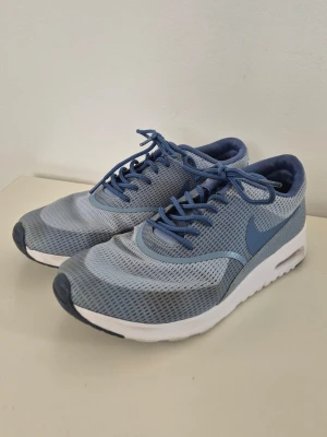 Nike Women's Air Max Thea Textile - Blue Grey / Ocean Fog / White - Ljusblåa Nike skor i fint skick! De är använda men hela och fina. Det står storlek 39 men innermåttet är ca 24,5 cm vilket motsvarar en 38.