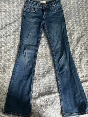 Blå bootcut jeans från Zara - Säljer ett par blå bootcut jeans från Zara med klassisk femficksmodell. Jeansen har normal midja och utsvängda ben, perfekta för en trendig och avslappnad look. Tillverkade i mjukt denimtyg.