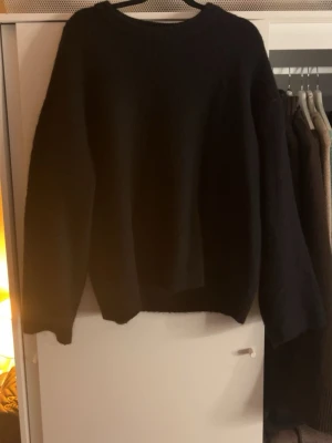 Svart stickad tröja från Bik Bok - Mysig svart stickad tröja från Bik Bok i mohairblandning. Tröjan har rund halsringning, långa ärmar och en enkel, oversized passform som passar perfekt till alla outfits.