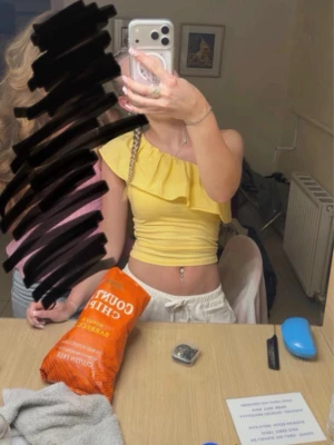 Gul offshoulder volang topp - Snygg gul offshoulder topp med volangdetalj. Croppad modell som passar perfekt till sommaren. Toppen är ärmlös och har en fräsch, ungdomlig vibe.