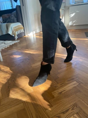 Svarta mocka stövletter med klack - Snygga svarta stövletter i mocka med spetsig tå och smal klack. Dragkedja på insidan och brunt foder i läder Perfekta för dig som gillar en stilren och trendig look. Passar perfekt att ha till ett par jeans eller liknande😍